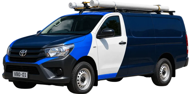 A licensed Kensington plumbing van loaded with pipe on the roof rack